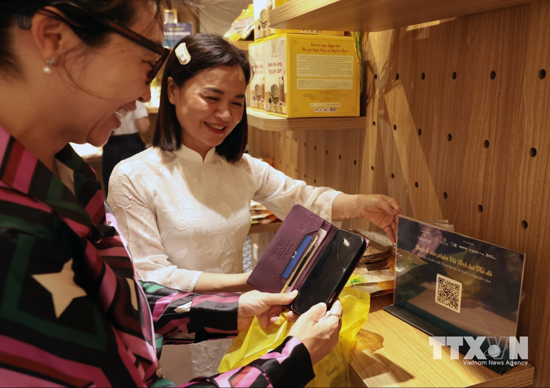 Khách mua sắm sản phẩm, trả tiền qua QR Code trong khuôn khổ chương trình “Sức sống hàng Việt” được tổ chức tại 62 Tràng Tiền, Hà Nội. (Ảnh: Trần Việt/TTXVN)